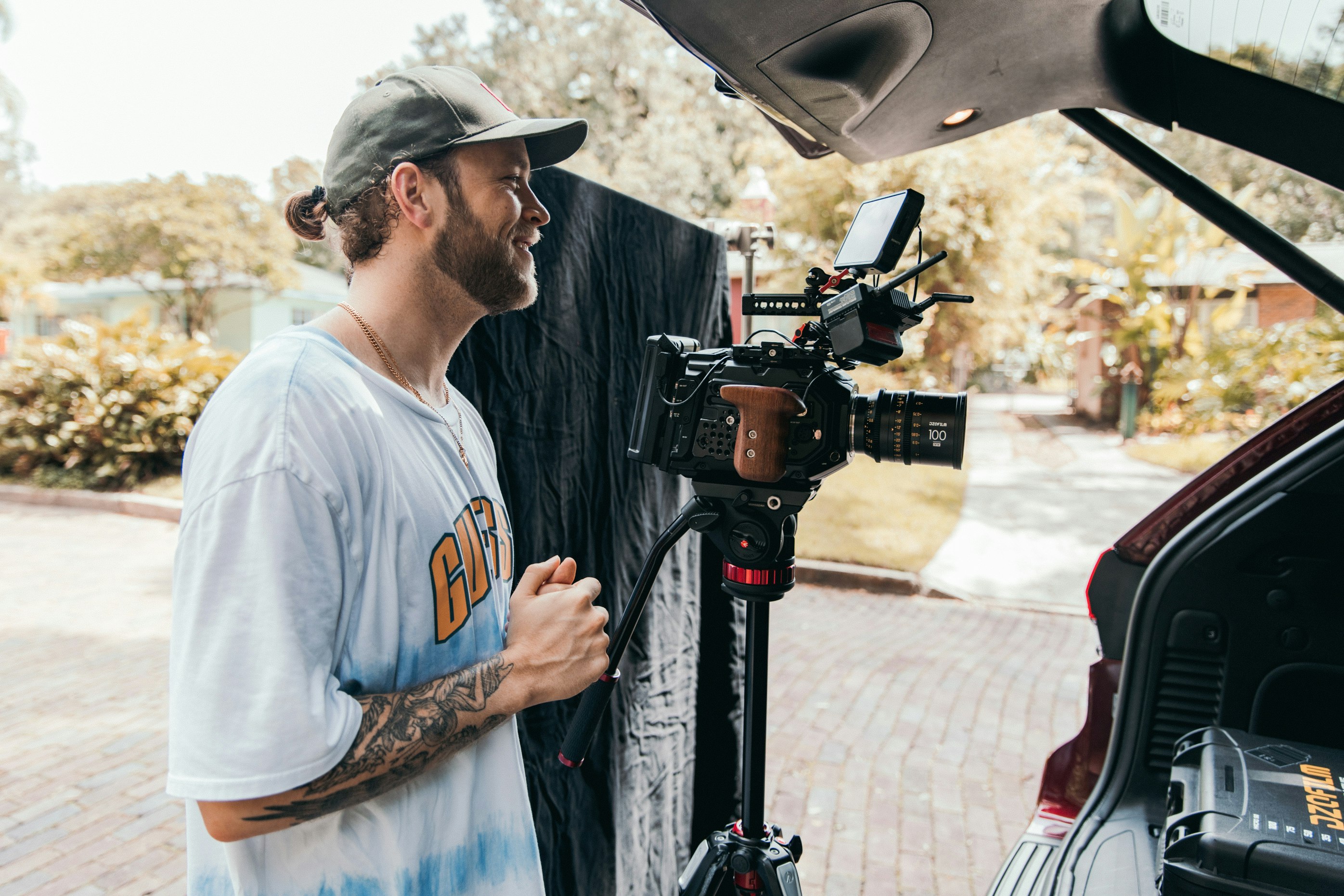 man in white crew neck t-shirt holding black video camera